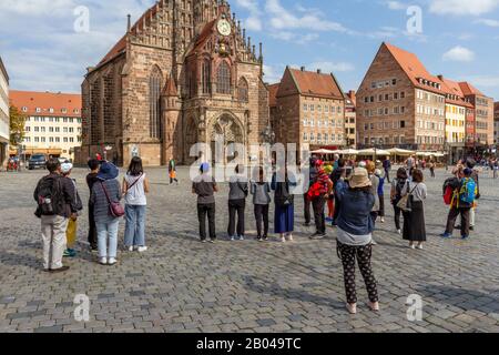 Ligne de touristes photographiant la Frauenkirche (Église notre-Dame), Hauptmarkt, Nuremberg, Bavière, Allemagne. Banque D'Images