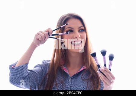 Femme tenant un assortiment de brosses à maquillage Banque D'Images