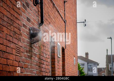 un évent de vapeur de chaudière sur le côté d'une maison en briques qui embellissera la vapeur lors d'une journée froide d'hiver Banque D'Images