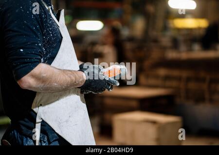 Gros plan des mains d'un opérateur de grue qui commande la commande dans un atelier métallique Banque D'Images