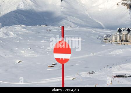 Marqueur rouge ensoleillé sur les pistes de ski enneigées dans les hautes montagnes d'hiver. Montagnes Du Caucase, Shahdagh, Azerbaïdjan. Banque D'Images