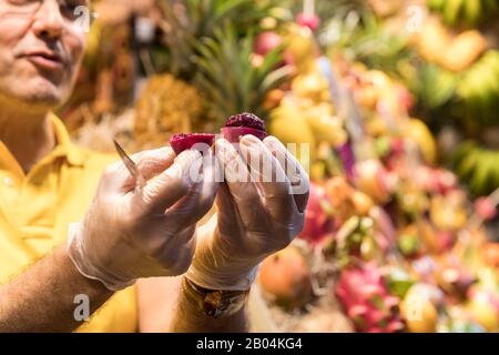 Démonstration de préparation alimentaire de fruits de cactus comestibles dans un étalage du marché alimentaire intérieur Mercado de Vegueta, Las Palmas Gran Canaria, îles Canaries Banque D'Images