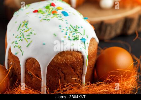 Gâteau de Pâques frais, cuit à la maison et décoré de givrage doux. Des œufs durs de couleur se trouvent sur la table comme un élément des vacances de Pâques. Artificiel Banque D'Images