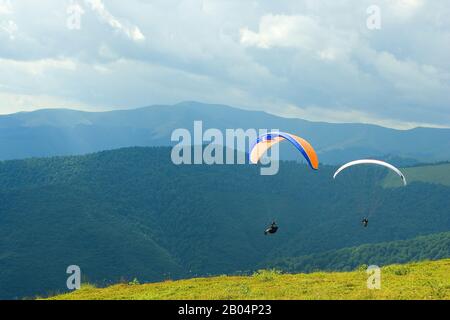 Photo sport extrême, les parapentes survolant les montagnes vertes de Carpates Banque D'Images