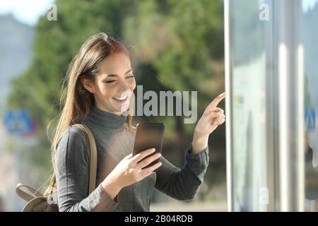 Bon train de banlieue vérifie le smartphone et planifie la table en attendant le transport dans un arrêt de bus Banque D'Images