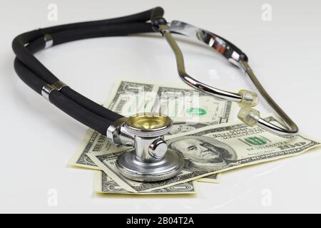 Vue en grand angle du stéthoscope et des billets en dollars américains sur fond blanc Banque D'Images