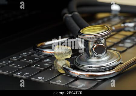 Gros plan du stéthoscope sur le clavier noir de l'ordinateur Banque D'Images