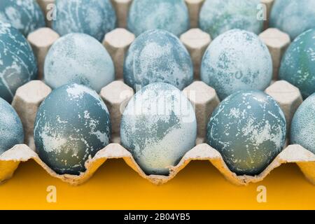 Œufs de Pâques de couleur bleue texturés sur fond jaune vif de vacances. Concept de vacances de printemps. Copyspace. Pose plate. Vue de dessus Banque D'Images