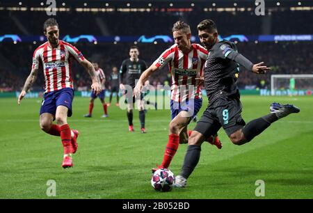 Marcos Llorente (au centre) et Roberto Firmino (à droite) de Liverpool affrontent le ballon lors de la ronde de 16 matchs de première jambe de l'UEFA Champions League à Wanda Metropolitano, Madrid. Banque D'Images