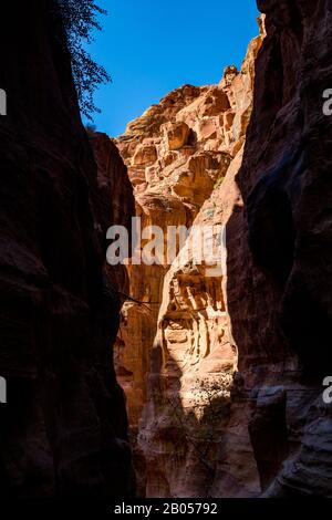 Gorge naturelle à couper le souffle appelée Al-Siq, sculptée dans les falaises rouges par le flux d'eau, le complexe de la ville antique de Petra et l'attraction touristique, Royaume hachémite de Jordanie. Jour d'hiver ensoleillé, ciel sans nuages Banque D'Images