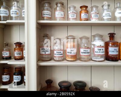 Ingrédients chimiques dans des bouteilles en verre, étiquetés en latin script, debout sur des étagères dans l'ancienne pharmacie historique Banque D'Images