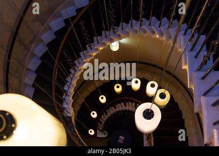 Escalier en colimaçon avec lumières qui pentent devant le haut dans un cadre sombre Banque D'Images