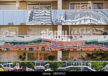 Bâtiment avec des bandes vitrées réfléchissantes qui reflètent, déformées, les bâtiments environnants, dans le quartier exclusif de Puerto Madero, à Buenos ai Banque D'Images