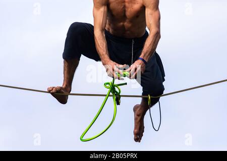 Un cliché en petit angle d'un homme musclé qui réalise des cascades à haute vitesse lors d'un festival célébrant les cultures traditionnelles. Les bras gonflent et tonifient nouent des nœuds Banque D'Images