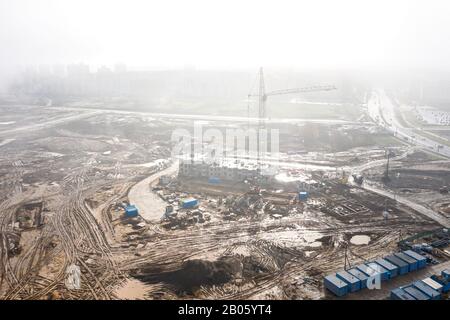 grue de construction en journée brumeuse sur la construction d'un bâtiment résidentiel. vue aérienne Banque D'Images