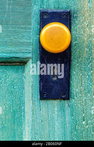 Bouton De La Vieille Porte Jaune Vintage Sur La Porte Verte Bleue Banque D'Images