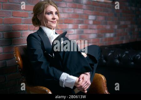 Femme d'affaires senior assis sur une chaise dans le yoga pose détente Banque D'Images