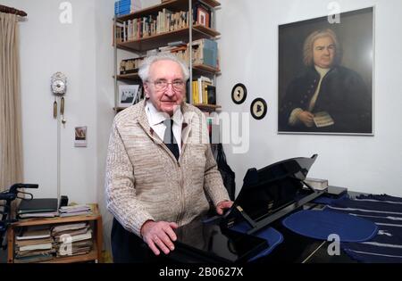 Rostock, Allemagne. 12 février 2020. Hartwig Eschenburg, musicien d'église, se tient à son piano à queue dans son appartement, et un portrait de Johann-Sebastian Bach est suspendu au mur. Le musicien de l'église recevra le Prix social Siemerling de la Fondation Epiphany de Neubrandenburg le 24 février 2020. Le prix est doté de 10 000 euros et est considéré comme le plus ancien prix social du nord-est. Crédit: Bernd Wüstneck/dpa-Zentralbild/ZB/dpa/Alay Live News Banque D'Images