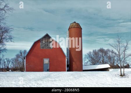 Kansas Red Country Barn avec un silo en hiver avec de la neige dehors dans le pays. Banque D'Images