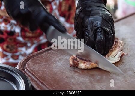 Mains Chef slicing steak juteux avec un couteau. Banque D'Images