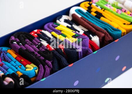 Boîte en carton bleu avec chaussettes colorées bien repliées. Style de vie minimaliste, concept de débrayer et de tri. Banque D'Images