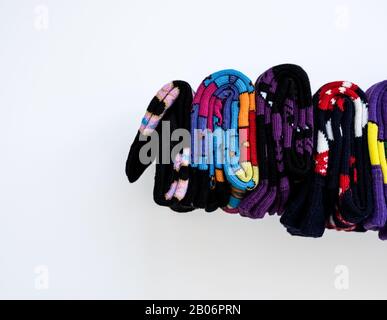 Plusieurs chaussettes en coton colorées roulent sur fond blanc. Banque D'Images
