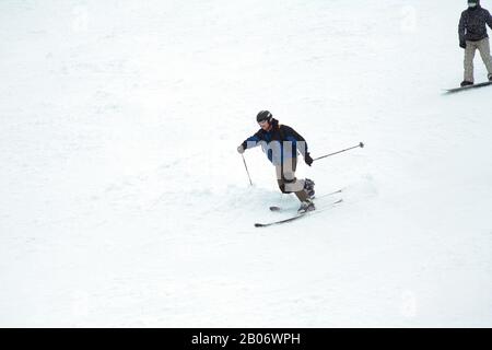 Station de ski. Le skieur descend rapidement sur une piste professionnelle enneigée. Un homme en snowboard. Sport professionnel. Banque D'Images