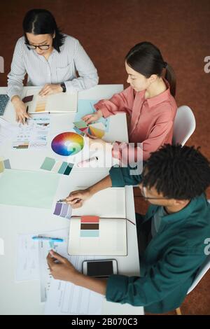 Équipe de concepteurs assis à la table et choisir la couleur pour la nouvelle collection ensemble en équipe au bureau Banque D'Images