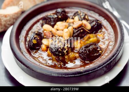 Tajine de poulet avec prunes et amandes, graines de sésame Banque D'Images