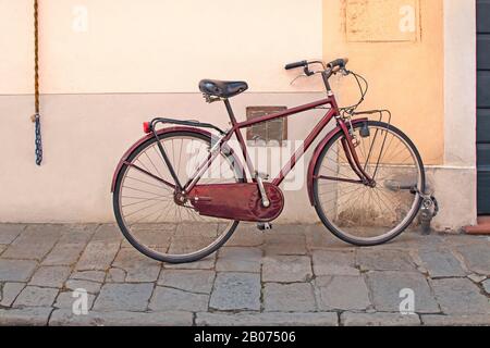 Ancien vélo rouge penchant contre le mur coloré Banque D'Images
