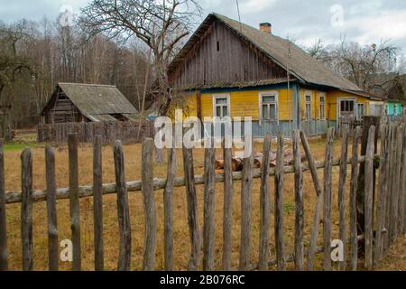 Village de style russe. Ferme en bois derrière une clôture de piquet en bois. Concept abandonné, ferme en Biélorussie Banque D'Images