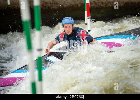 Gros plan d'action d'un athlète de slalom canoe de GB négociant les pôles des portes de slalom sur l'eau blanche dans la classe C1W. Banque D'Images