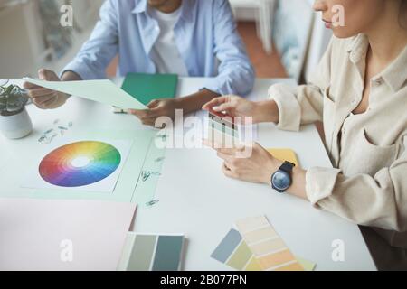 Gros plan de groupe de concepteurs assis à la table et choisir la couleur pour le futur projet Banque D'Images