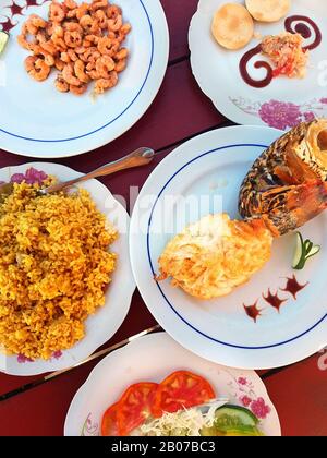 Homard grillé sur une assiette, crevettes, légumes et riz dans un restaurant de plage cubain Banque D'Images