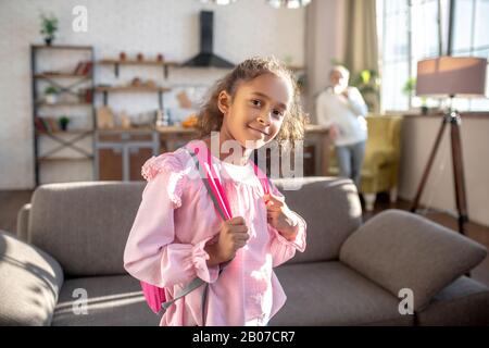 Jolie fille à peau sombre avec des cheveux bouclés souriant bien Banque D'Images