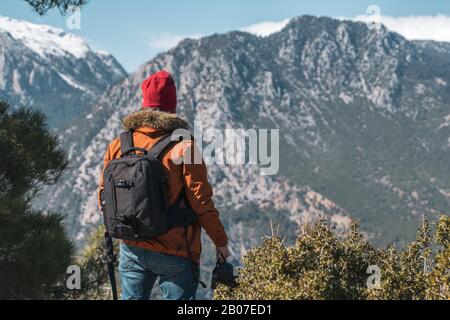 Jeune photographe caucasien en haut d'une montagne le jour clair. Banque D'Images