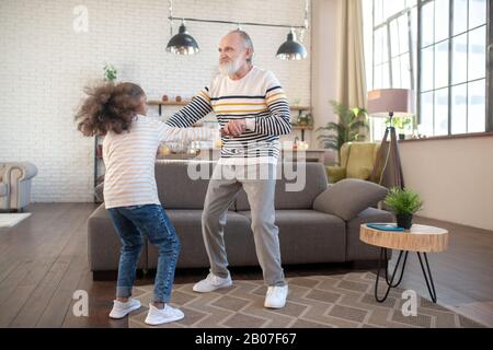 Fille à peau foncée en Jean s'amusant avec son grand-père Banque D'Images
