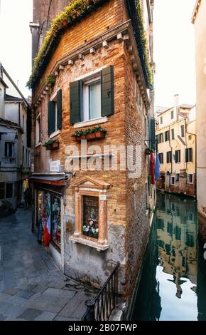 Vue sur la petite maison colorée entre le canal et la rue à Venise, en Italie Banque D'Images