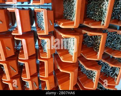 Vis dans des boîtes de rangement orange dans un atelier Banque D'Images