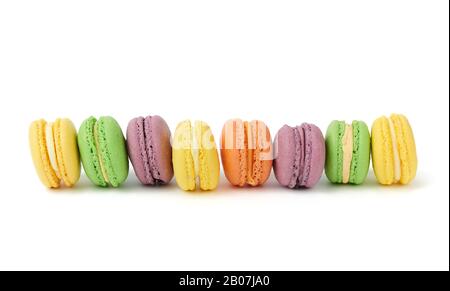 gâteaux de macarons ronds multicolores isolés sur fond blanc, supports de dessert en rangée Banque D'Images