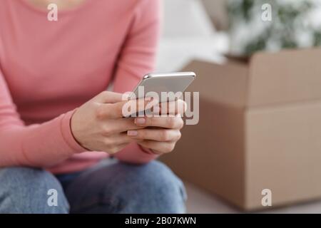 Femme méconnaissable utilisant un téléphone portable moderne et faisant des achats en ligne Banque D'Images