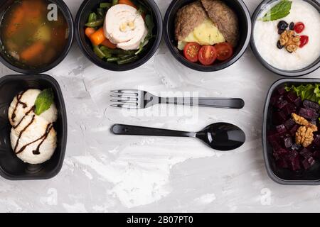 porridge d'orge, salade de betteraves, dessert, soupe à la crème. Nourriture saine dans la boîte. Style de vie, repas de jour. Cuillère et fourche en plastique Banque D'Images