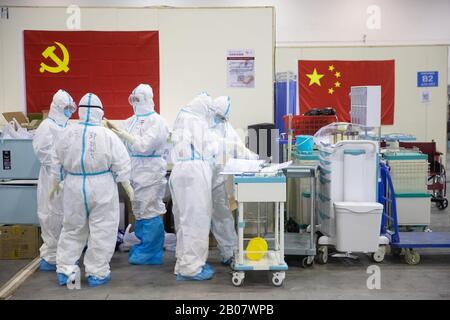 Les travailleurs médicaux bien équipés parlent à un hôpital de cabine mobile Fangcang à Wuhan, dans la province de Hubei en Chine centrale, le 17 février 2020. Banque D'Images