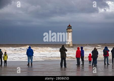 Les gens se réunissent sur le front de mer pour regarder et prendre des photos de Storm Ciara au phare de fort Perch Rock à New Brighton Wallasey Royaume-Uni Banque D'Images