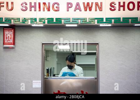 Un ouvrier de la boutique de pawn a vu utiliser le masque facial comme une mesure préventive à la suite de l'épidémie de Coronavirus qui a commencé dans la ville chinoise de Wuhan. Banque D'Images