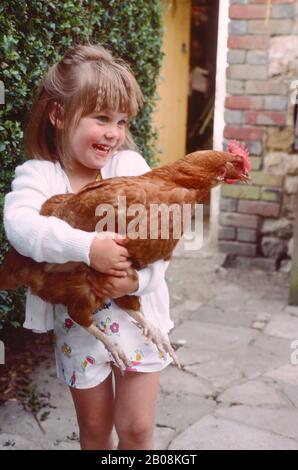 petite fille tenant un poulet Banque D'Images