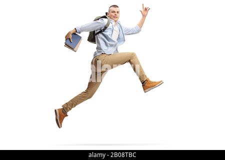 Tir sur toute la longueur d'un grand gars tenant des livres et sautant isolé sur fond blanc Banque D'Images