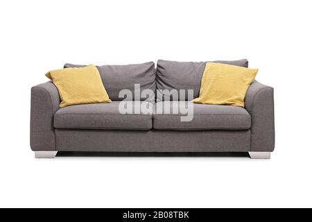 Studio tourné d'un canapé gris avec coussins jaunes isolés sur fond blanc Banque D'Images