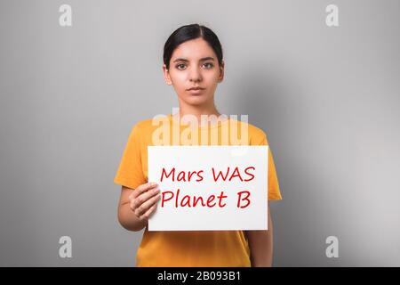 jeune femme sérieuse et attrayante militante écologique tenant un placarde Banque D'Images