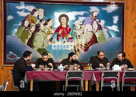 Les prêtres mangent le dîner sous une peinture à l'huile religieuse "La dernière Cène de Jésus" dans le séminaire catholique dans le district de Maadi, au Caire, en Egypte Banque D'Images